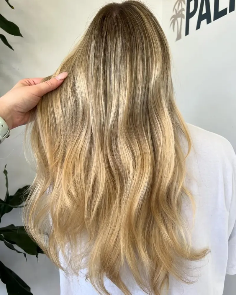 Long blonde hair with soft dimensional color, styled in loose waves at Palm Beach Hair Co.